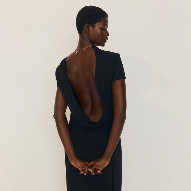 Women wearing a black dress with open back by Khaite 