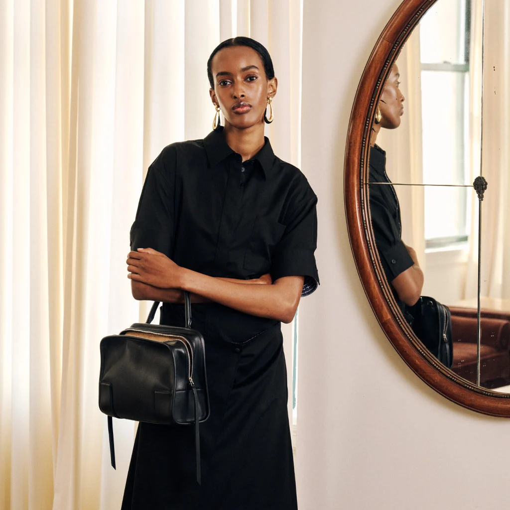 Model wearing Loewe shirtdress holding Amazona 180 handbag 