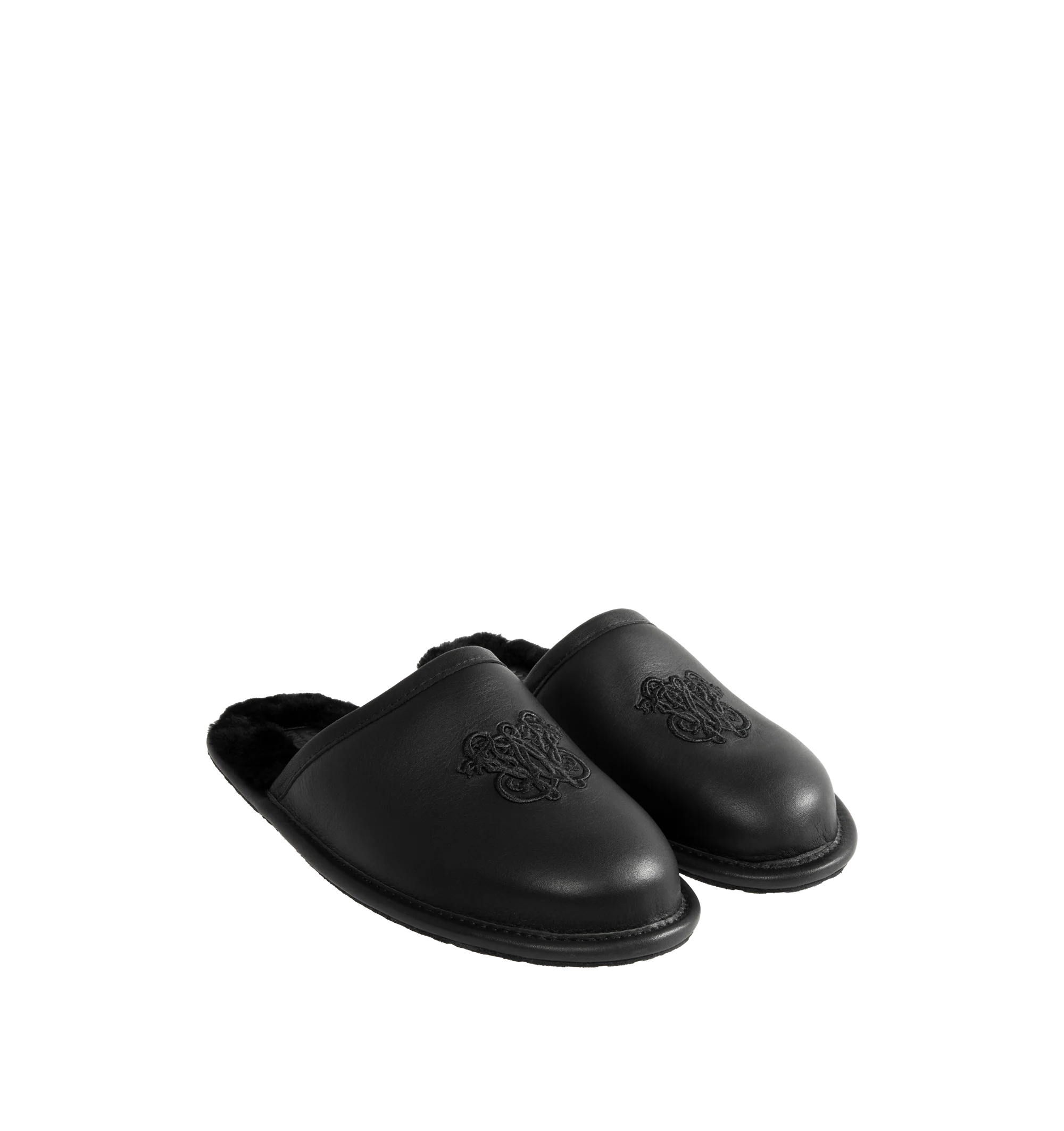 Image 2 of 4 - BLACK - UGG x Willy Chavarria Leather Hotel Slippers are crafted from black leather and feature a luxury reinterpretation of the classic hotel slipper silhouette. Designed with Chavarria's crest embroidered, and lined with UGG's signature plush sheepskin for exceptional comfort. Main Material: Leather. Lining: Sheepskin. Unisex style in men's sizes. 