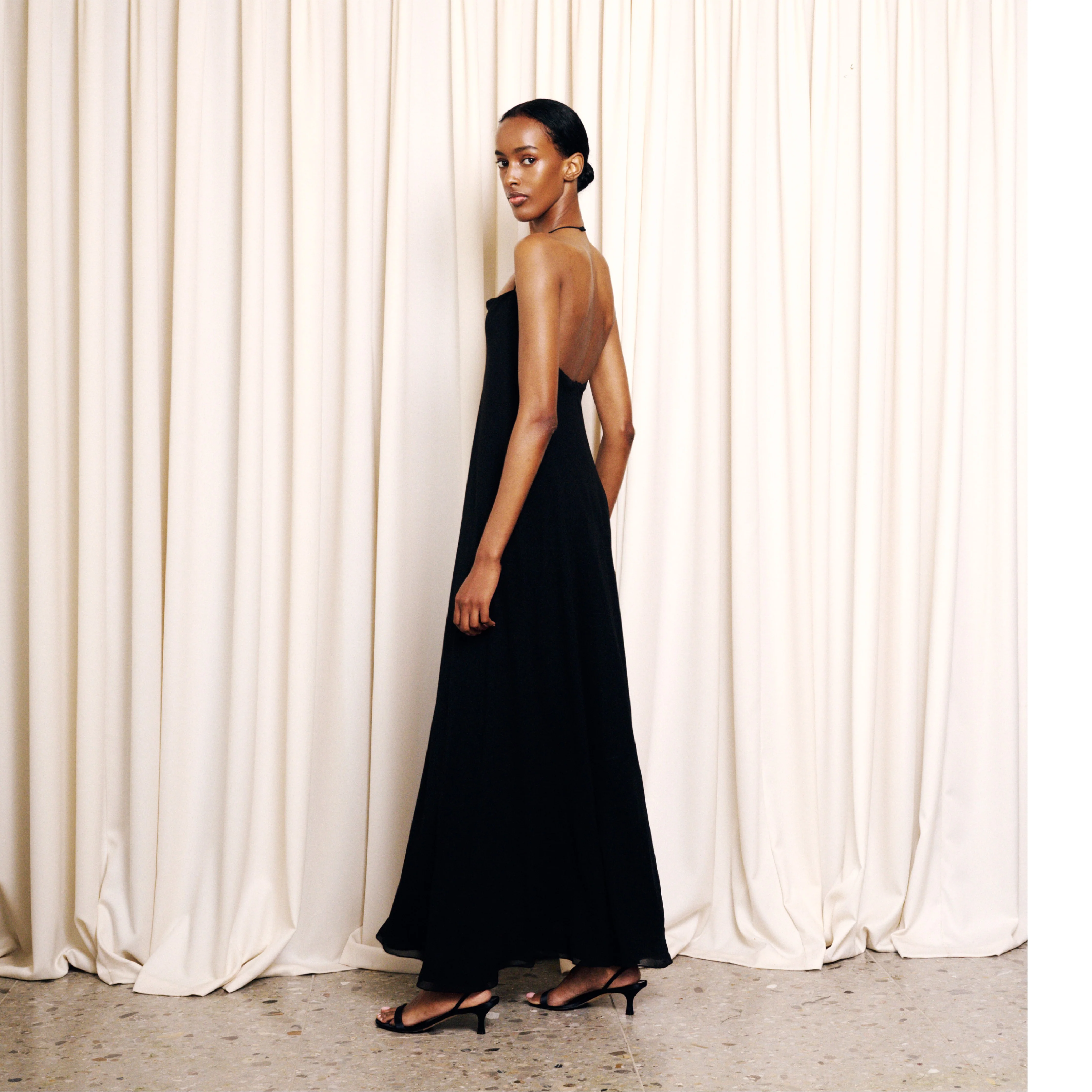 Image 3 of 4 - BLACK - The Row Women's Javier Dress is crafted from lightweight silk georgette and features a bias-cut silhouette with a fitted waist, flared hem, and a squared neckline accented by a slim halter strap. This designer silk dress combines exceptional Italian craftsmanship with an airy, fluid drape, creating an effortlessly elegant silhouette for day-to-evening occasions. Main Material: 100% Silk. Made in Italy. 