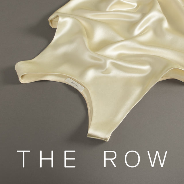 Beige bodysuit on a gray background with 'THE ROW' branding. 
