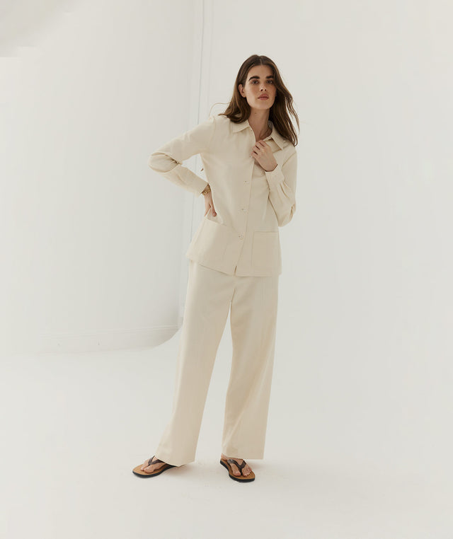 Woman wearing a beige shirt and pants by The Row 