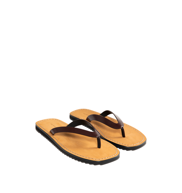 Image 2 of 4 - BROWN - THE ROW City Flip Flop featuring glossy calfskin leather with contrast leather footbed, stitched detailing, and lightly treaded rubber sole. 100% calfskin leather. Made in Italy. 
