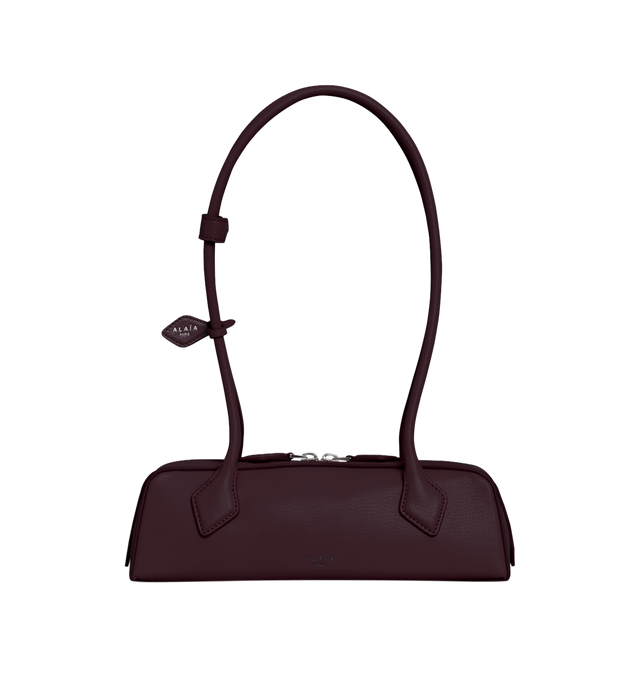 Image 1 of 1 - RED - The Alaia Le Teckel Shoulder Bag has an elongated shape, double zip closure, and tubular handles with two decorative ties. It also has a small removable mirror on the inside pocket. L 27 X H 9 X D 8. 100% calfskin. Made in Italy.