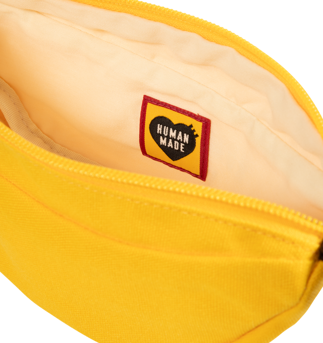 Image 3 of 3 - YELLOW - HUMAN MADE Banana Pouch featuring banana-shaped pouch with a loop attached, made from thick cotton canvas that holds its shape and dye-printed brand logo, fruit sticker style heart logo. 100% cotton.  