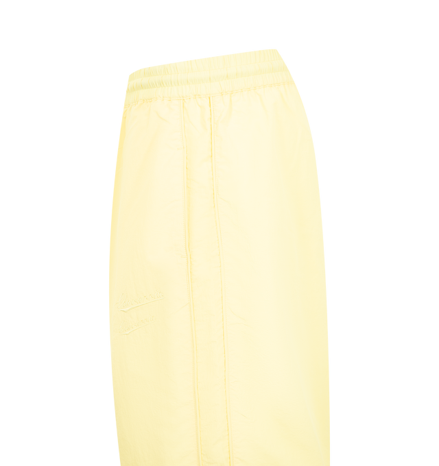 Image 3 of 3 - YELLOW - WILLY CHAVARRIA Bad Boy Track Pant featuring a relaxed, easy fit, side pockets, elastic waistband and hems, lightweight, stacked double CHAVARRIA logos at the left pocket and double stripes down legs. 100% nylon. 