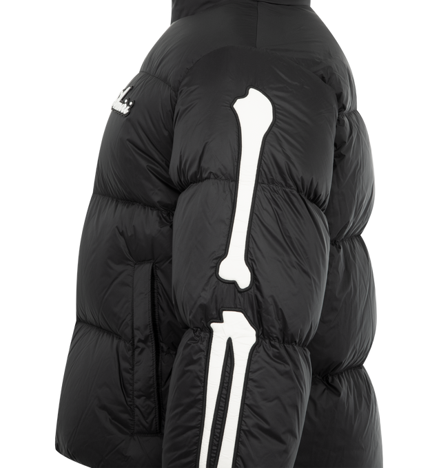 Image 3 of 3 - BLACK - AMIRI Bones Down Puffer Jacket featuring a logo at the chest, signature bone graphics on each sleeve, stand collar, drop shoulders, long sleeves, elasticized cuffs, waist zip pockets and two-way front zip closure. 100% nylon.