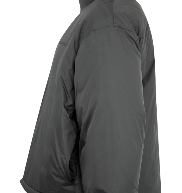 Image 3 of 3 - GREY - FEAR OF GOD ESSENTIALS Ripstop Nylon Puffer Jacket featuring ripstop nylon, matte appearance with water repellant properties, 3D Essentials graphic on the chest, relaxed, rounded silhouette, high neck, side pockets, full zip front, elasticized piping on the cuffs and waist hem, bungee toggles at the waist hem for adjustable styling and a Fear of God Essentials rubberized label stitched at the back collar. 100% matte nylon.