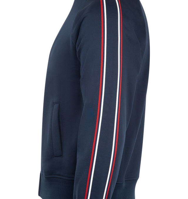 Image 3 of 3 - NAVY - SAINT LAURENT Track Jacket featuring a stand collar, zip front, raglan sleeves with contrast piping, two welt pockets at the front and ribbed cuffs and hem. 57% cotton, 43% nylon. Made in Italy.