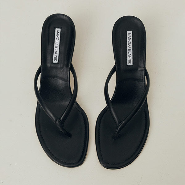 Pair of black sandals with 'Manolo Blahnik' branding on a white background