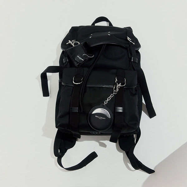 Black backpack with a Maison Margiela tag on a white background