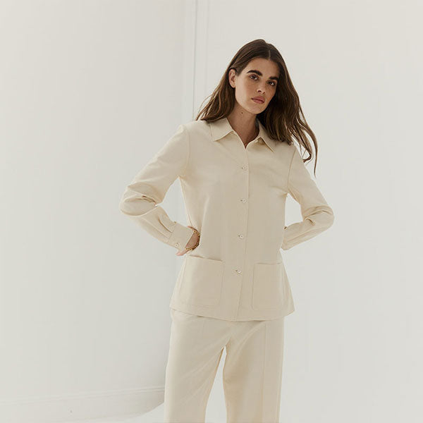 Woman wearing a beige button-up top and pants by The Row