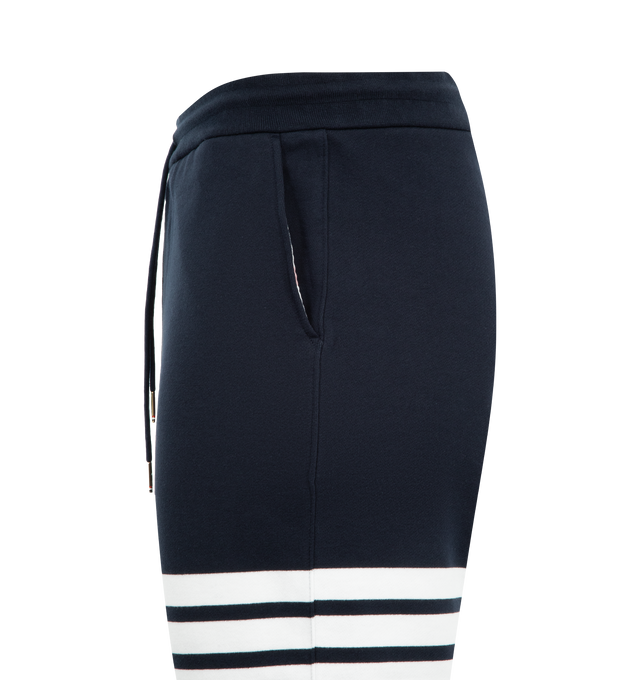 Image 3 of 3 - NAVY - THOM BROWNE Classic Loopback 4 Bar Sweatpant featuring iconic 4-Bar detailing, drawstring waistband with silver tone aglets, slip side pockets, single back welt pocket, name tag applique above left cuff and signature striped grosgrain loop tab at back waist. 100% cotton. Made in Japan. 