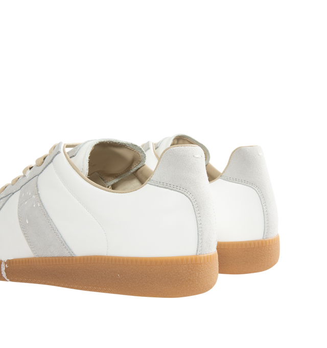 Image 3 of 5 - WHITE - MAISON MARGIELA High Quality Luxury Sneakers featuring a classic low-top silhouette, contrast of matte leather and a patent sprayed finish, paint splatter detail, lace-up construction and rubber sole. Made in Italy.