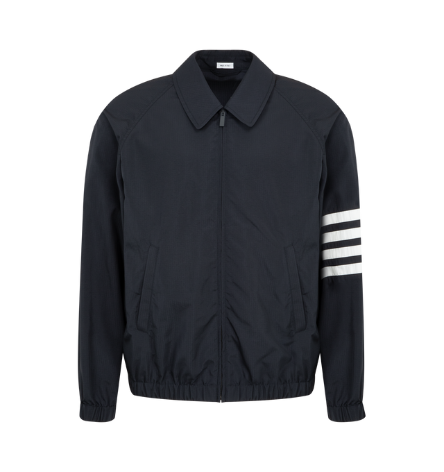 Image 1 of 3 - NAVY - THOM BROWNE Ripstop Raglan Coach Jacker featuring front two-way zip closure, raglan sleeves, welt hand pockets, one interior pocket, elasticated cuffs and hem, engineered 4-bar detailing and signature striped grosgrain loop tab. 81% polyamide, 19% polyester. Made in Italy.