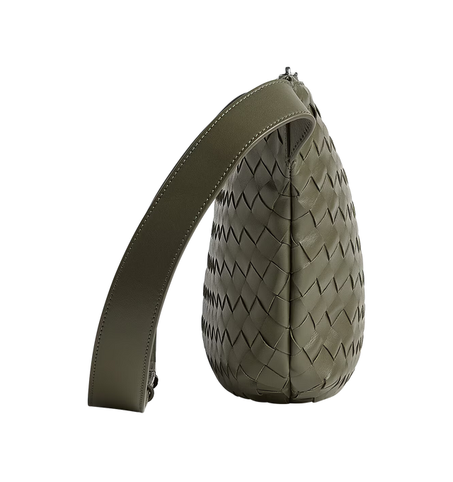 Image 2 of 3 - GREEN - BOTTEGA VENETA Intrecciato Day Sling Bag featuring intrecciato leather round sling-bag with adjustable strap, single interior zipped pocket and two flat open pockets and zip closure. Calfskin. Lining: canvas. 10.4" x 18.5" x 2.0". Made in Italy. 