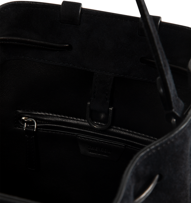 Image 4 of 4 - BLACK - THE ROW Backpack 9 in suede featuring a toggle fastening top, smooth leather trim, gold hardware, 2 adjustable, rivet fastening straps, 1 top handle, logo embossed purse feet at underside, single interior compartment with 1 slit pocket, key ring inside and suede lining. 10.5 W x 10.5 H. 100% calfskin leather. Made in Italy.