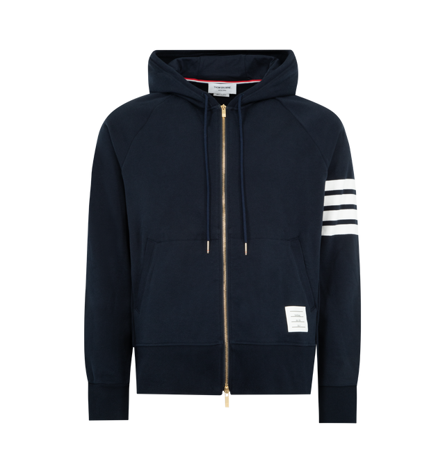Image 1 of 3 - NAVY - THOM BROWNE Classic Loopback 4 Bar Zip Up Hoodie featuring brass 2-way zip closure, integrated hood with stripe trim, 4-bar stripe detail at left sleeve and kngaroo front pocket with name tag applique. 100% cotton. Made in Japan.