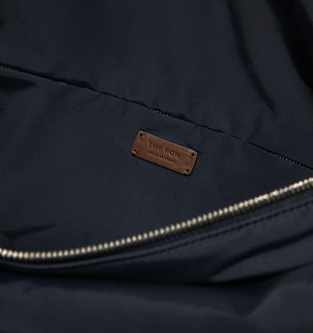 Image 5 of 5 - NAVY - THE ROW E/W Logan Bag featuring contoured shoulder bag in crisp technical nylon with turned-edge construction, woven adjustable flat strap, leather piping, and top zipper closure. 15.75 x 10.63 x 7.48 in. 45% cotton, 25% nylon, 30% calfskin leather. Lined in 56% cotton, 44% nylon. Made in Italy.