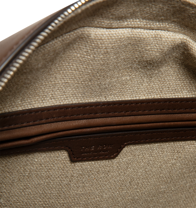 Image 3 of 3 - BROWN - THE ROW India 12 Canvas Bag featuring bowling bag in heavy cotton canvas with tubular leather handles, branded metal padlock and key, and zipper closure. 35% linen, 30% calfskin leather, 25% cotton, 5% polyamide, 5% polyester. Lining: 100% linen. Made in Italy.