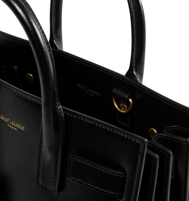 Image 3 of 3 - BLACK - SAINT LAURENT Sac De Jour Nano Bag featuring accordion sides, snap button closure, top handles, bronze-tone hardware, removable zipper compartment, and leather lining. 90% calfskin, 10% brass. Made in Italy.