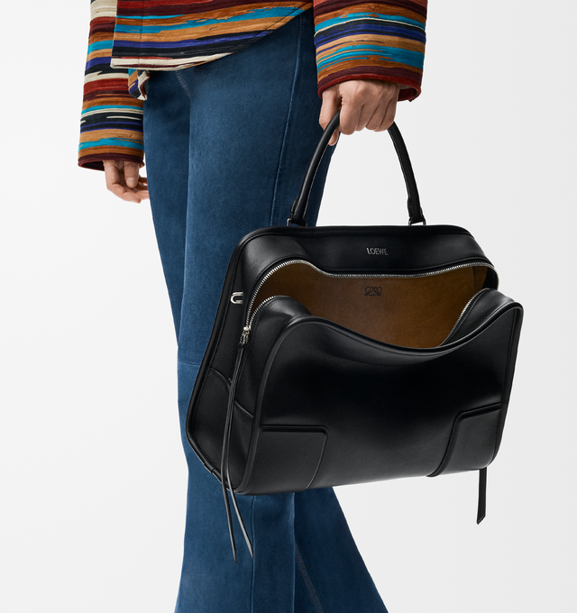 Image 2 of 16 - BLACK - Loewe Amazona 180 large bag takes on a relaxed silhouette anchored by a single toron top handle. It is designed to be carried open, while a concealed closure secures the main compartment. Removable shoulder and crossbody straps make it highly versatile. This large version is crafted in soft calfskin. Three carry options: short handle, removable shoulder strap and crossbody. Features zip closure with two leather zip pullers, two compartments, main compartment closed with magnetic clos