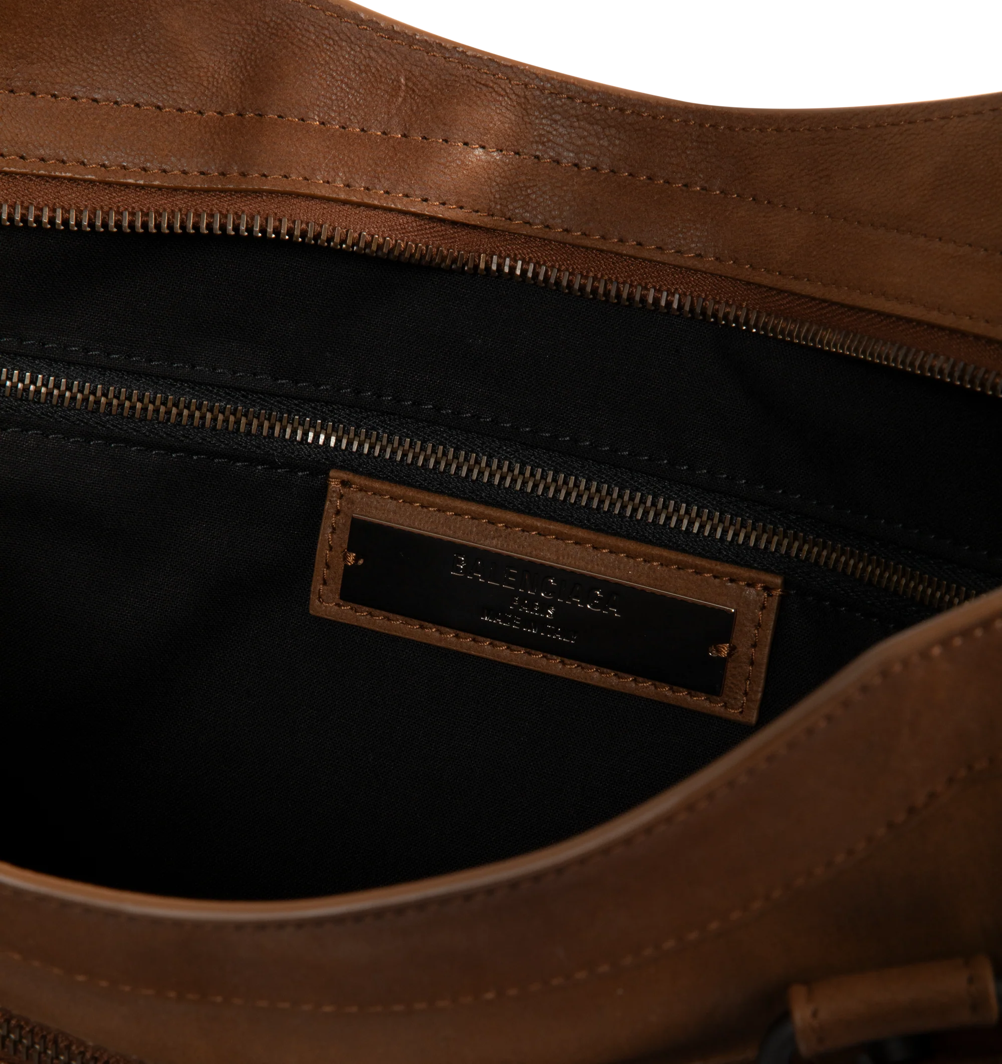 Image 3 of 3 - BROWN - Balenciaga Men's Le City Bag Large is crafted from vintage goatskin and features the house's iconic relaxed silhouette with two hand-braided handles detailed with waxed cord. Designed for hand or crossbody carry, this designer bag features an adjustable and removable shoulder strap with shoulder pad, brass hardware, a double-sided zip closure with long tails and knotted leather puller, front zipped pocket, interior zipped pocket, removable mirror with tone-on-tone Balenciaga logo, and