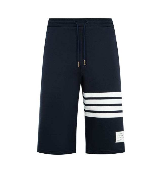 Image 1 of 3 - NAVY - THOM BROWNE Classic Loopback 4-Bar Sweatshorts featuring drawstring waistband with silver tone aglets, engineered 4-bar stripe detail at left thigh, name tag applique above left cuff, slip side pockets, single back welt pocket and signature striped grosgrain loop tab at back waist. 100% cotton. Made in Japan.