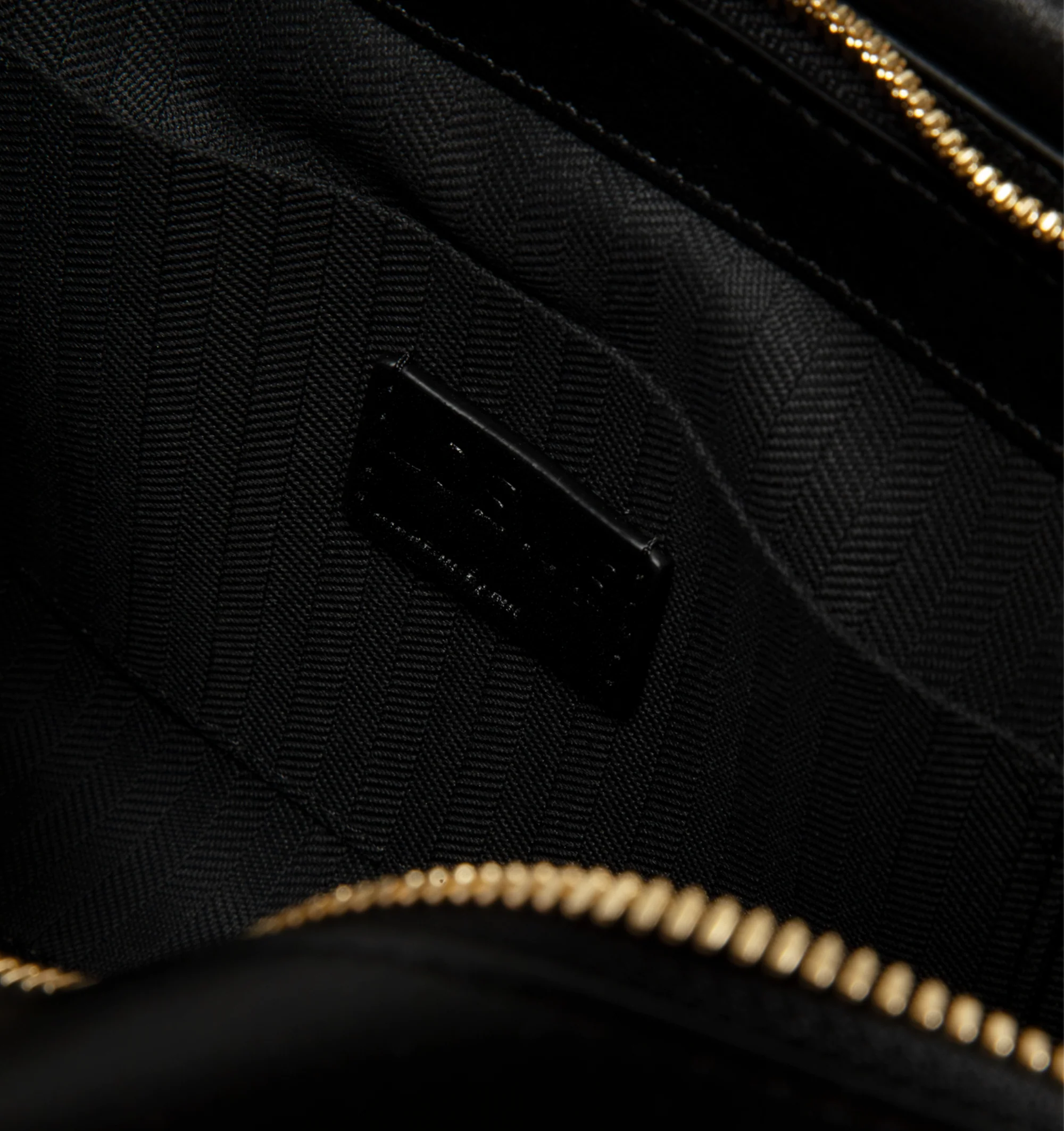 Image 3 of 3 - BLACK - Loewe Small Whisker Bag is crafted from black glazed calfskin and features a slouchy silhouette with a structured handle and oversized zip opening. Designed for shoulder, crossbody, or hand carry, it includes a detachable strap with rotating dog clips, articulated zipper pulls, foldable D-rings, an exterior flat pocket, and an interior flat pocket. Gold-tone hardware and embossed Loewe and Double L branding complete the design. Fits a large phone, small wallet, sunglasses, and keys. M
