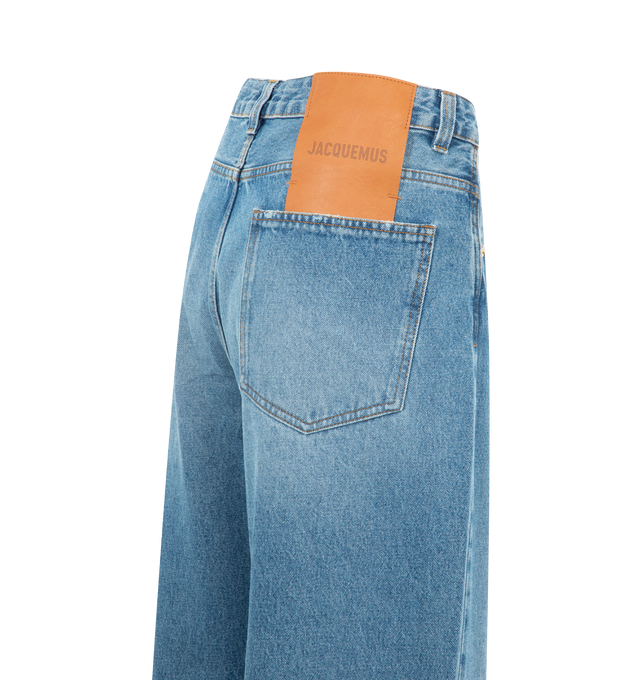 Image 2 of 2 - BLUE - JACQUEMUS Oversized Jeans featuring mid rise, washed indigo denim, long wide leg, J belt loop, five pockets, metal studs and rivets, button fly, large denim patch above back pocket and contrast stitching. 100% cotton. Made in Italy.