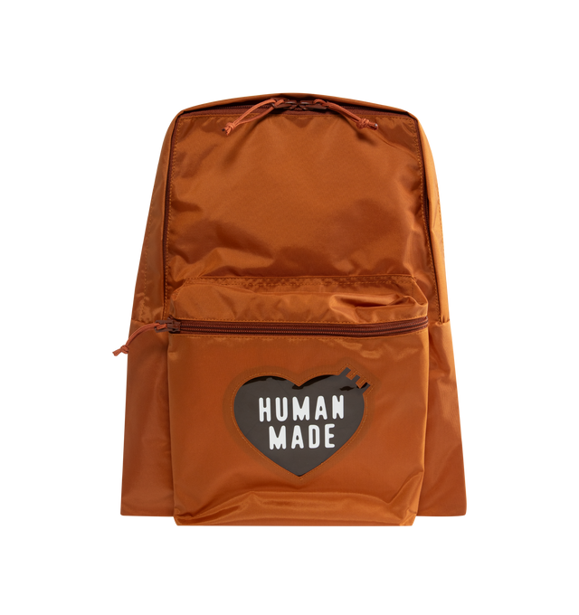 Image 1 of 3 - BROWN - HUMAN MADE Daypack featuring lightweight nylon Oxford exterior, PVC heart logo on the front, two-way zip closure, logo printed on top handle, front zip pocket, shoulder strap features a leather brand logo panel and one interior laptop sleeve. Capacity: around 20 L. 39cm x 34cm x 17cm.