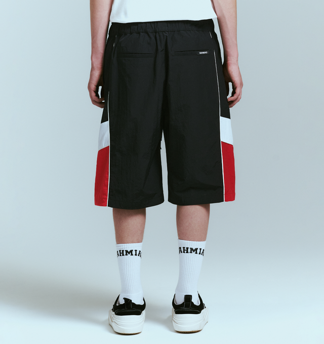 Image 4 of 4 - BLACK - NAHMIAS Warm Up Short featuring ollie wave design, colorblocking, elastic waist with drawstring, embroidered logo, two side pockets and back welt pockets. Nylon.