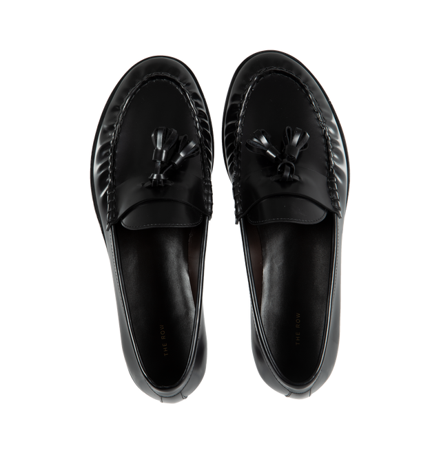 Image 4 of 4 - BLACK - THE ROW Loafer featuring sleek calfskin leather with natural pleating effect and tassel detailing. 100% leather. Made in Italy.