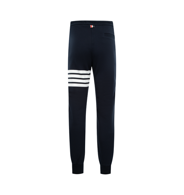 Image 2 of 3 - NAVY - THOM BROWNE Classic Loopback 4 Bar Sweatpant featuring iconic 4-Bar detailing, drawstring waistband with silver tone aglets, slip side pockets, single back welt pocket, name tag applique above left cuff and signature striped grosgrain loop tab at back waist. 100% cotton. Made in Japan.